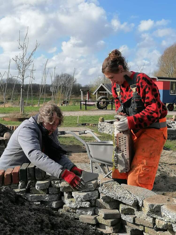 Henk Pleiter samen met dochter Chantalla Pleiter aan het stapelen bij het Suikerunie-terrein